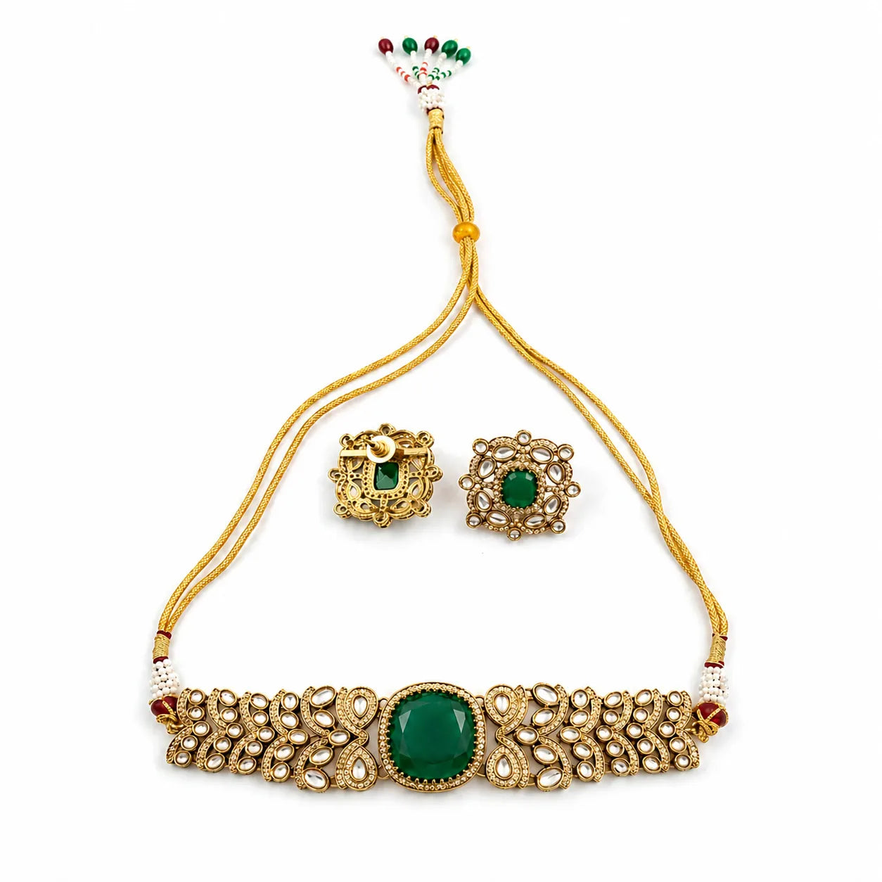 Gold jewelry set with green stones on a white background