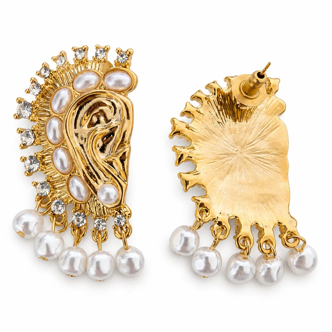 Gold and pearl earrings on a white background