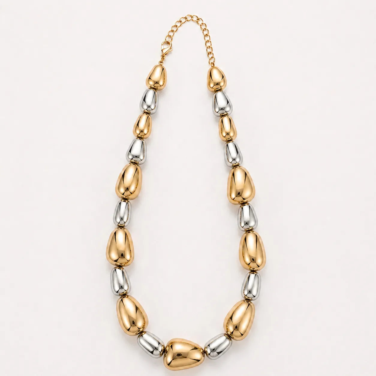 Necklace with gold and silver beads on a light gray background