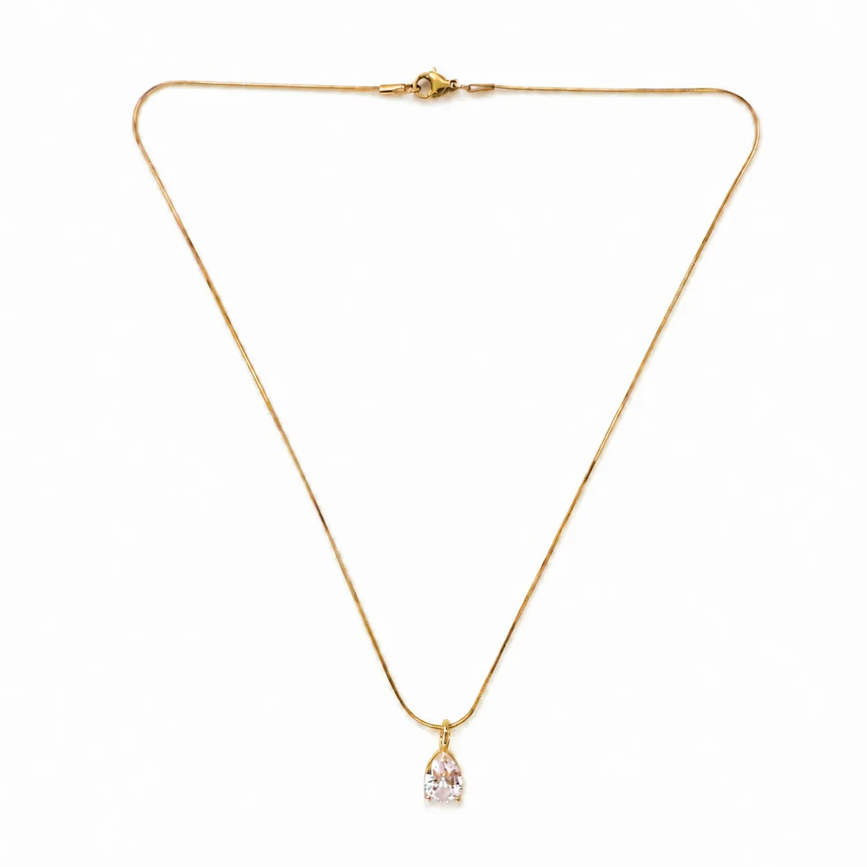 Gold necklace with a pink pendant on a white background