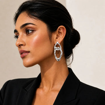 Woman wearing a silver earring with a neutral background