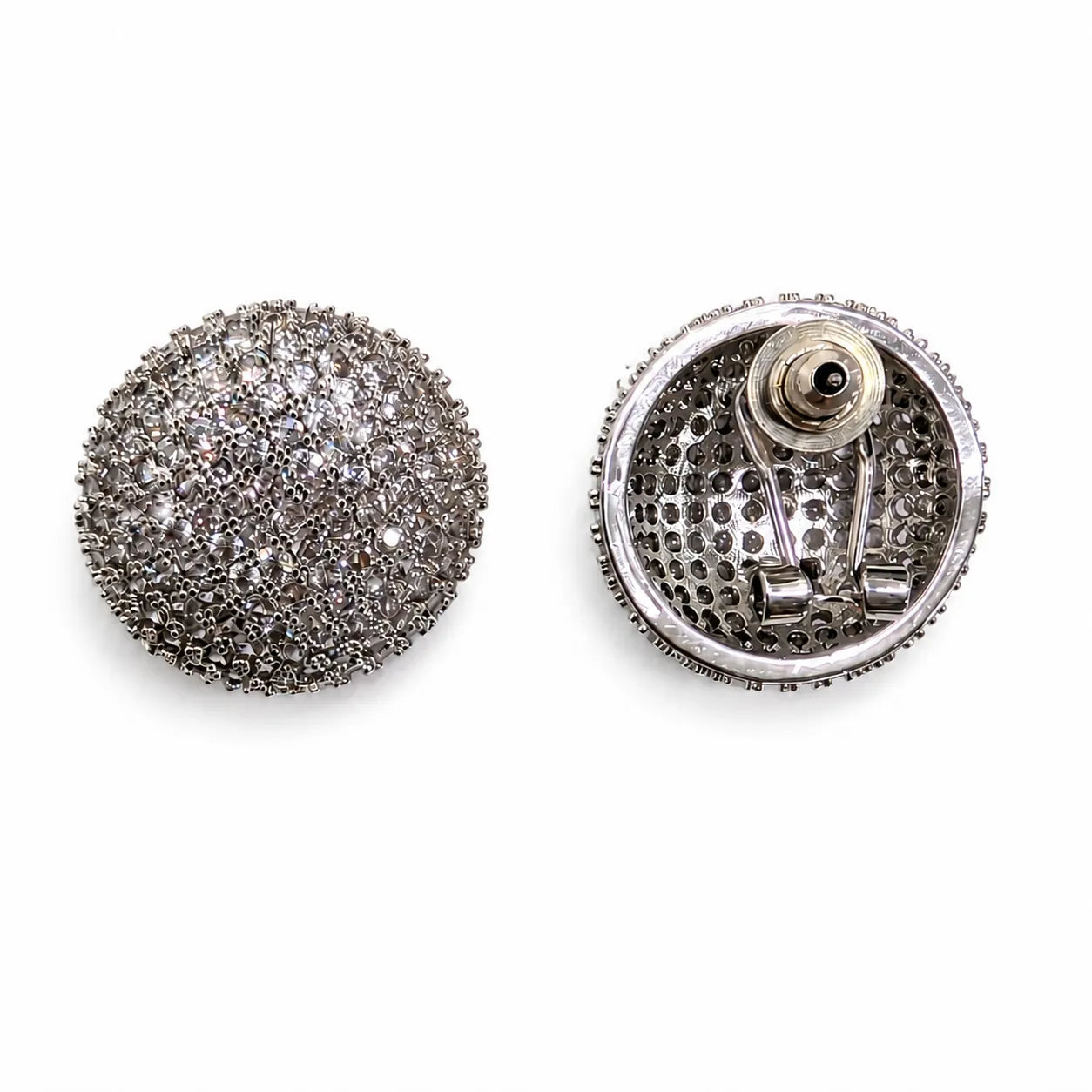Silver button with intricate design on a white background