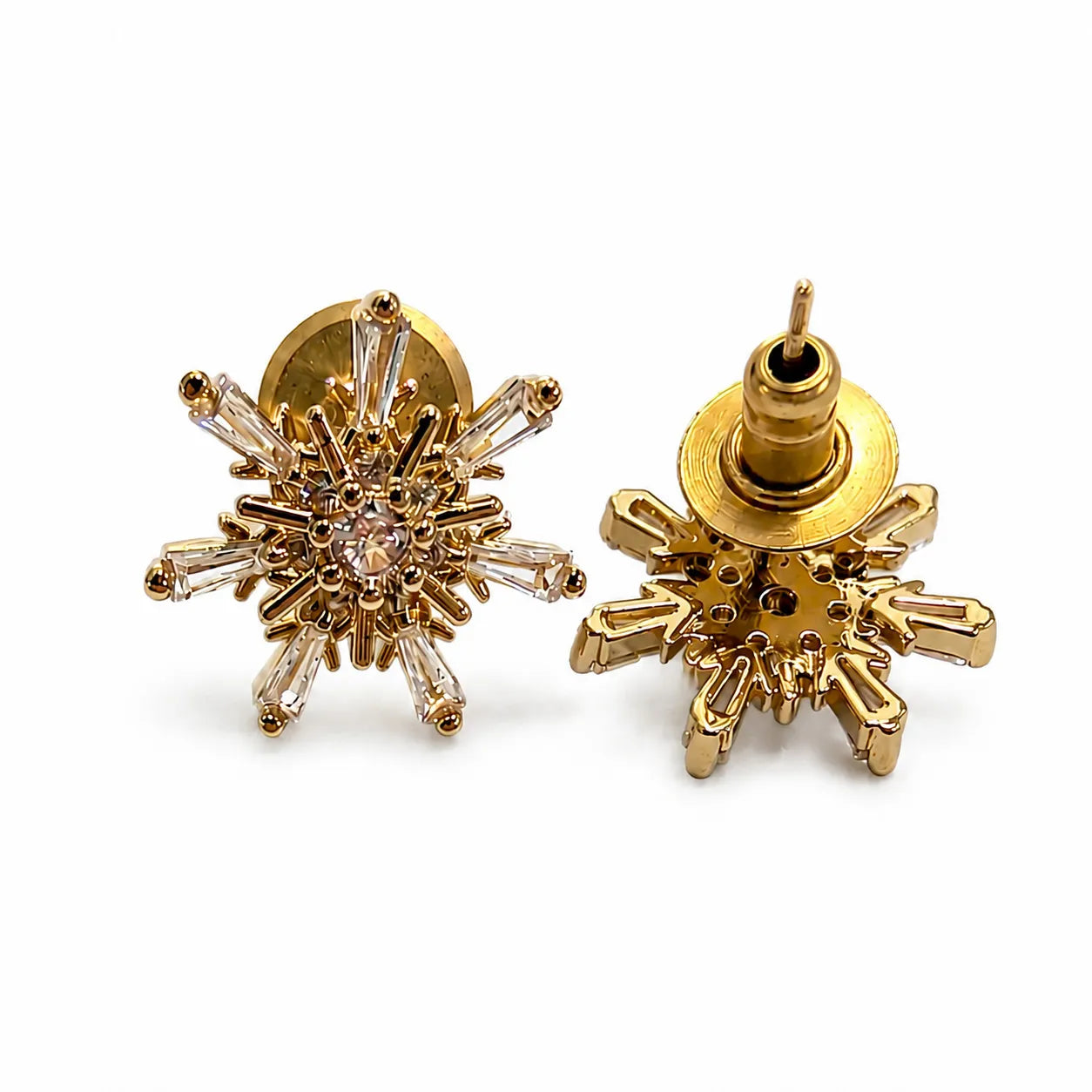Gold snowflake-shaped earrings on a white background