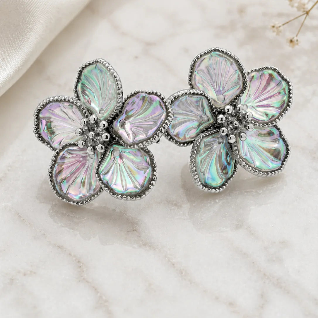 Floral brooch with iridescent stones on a marble surface