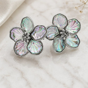 Floral brooch with iridescent stones on a marble surface