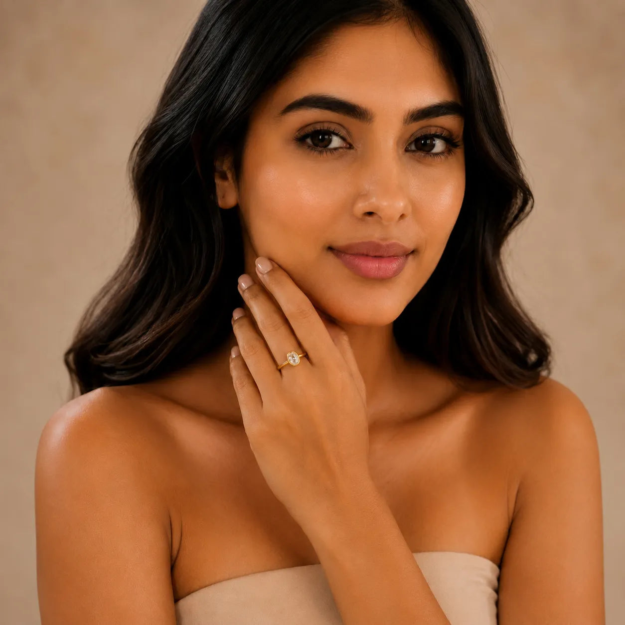 Woman wearing a ring on her finger against a beige background