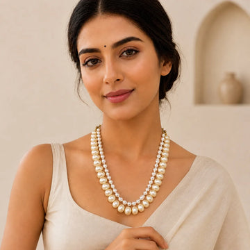 Woman wearing a pearl necklace against a neutral background