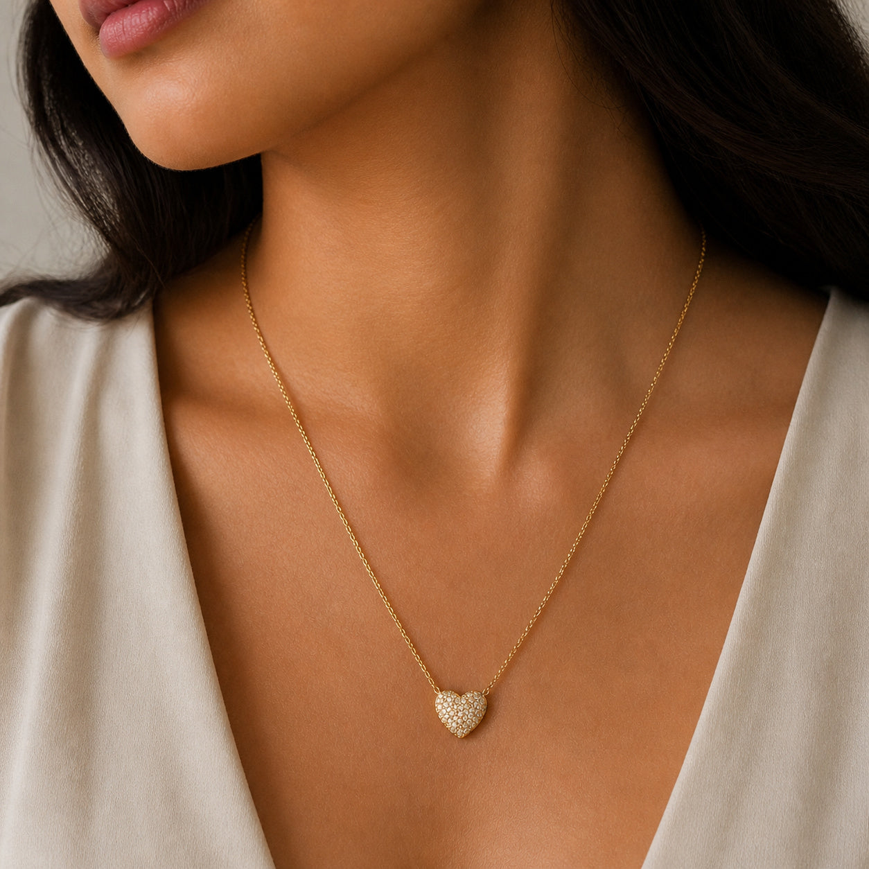 Close-up of a woman wearing a gold heart-shaped necklace.