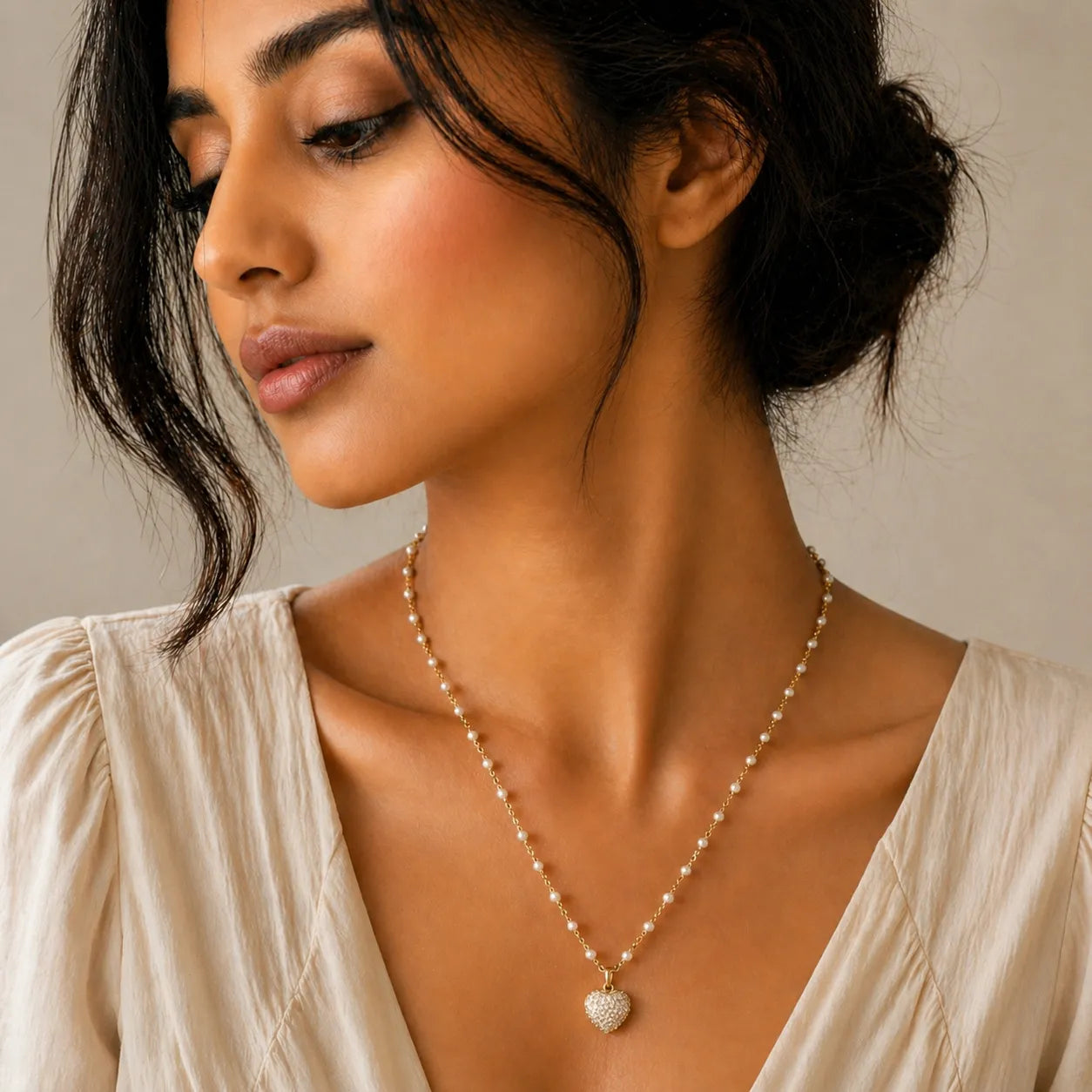 Woman wearing a pearl necklace with a neutral background