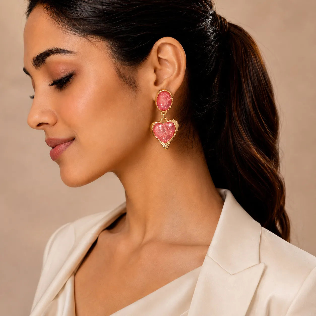 Woman wearing pink heart-shaped earrings with a beige background