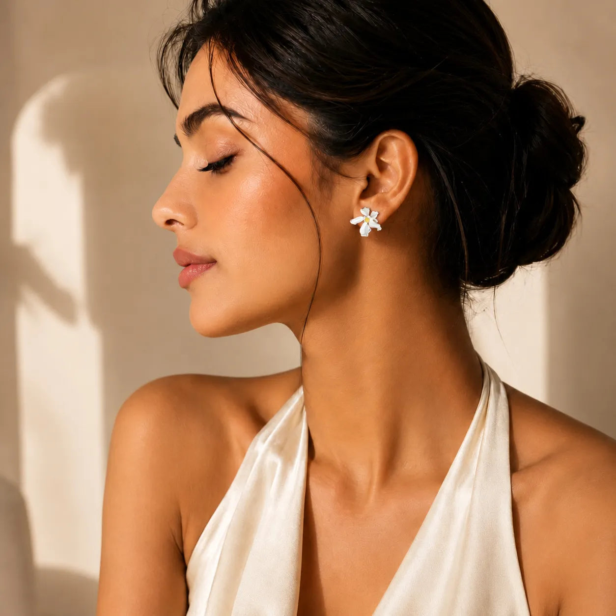 Woman wearing a white halter top with a neutral background