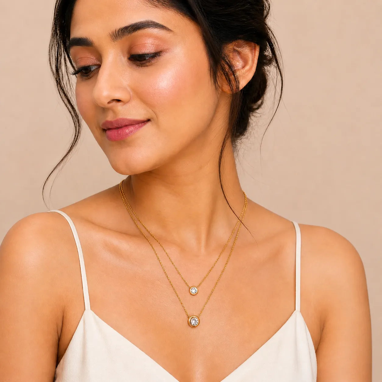 Woman wearing a gold necklace with a beige background