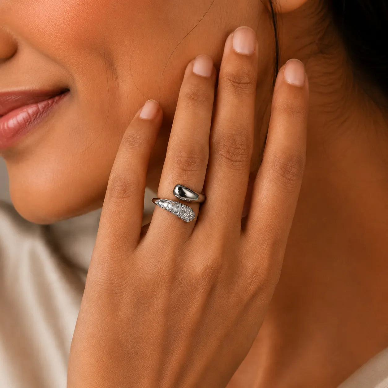 Close-up of a hand with a diamond ring on a neutral background