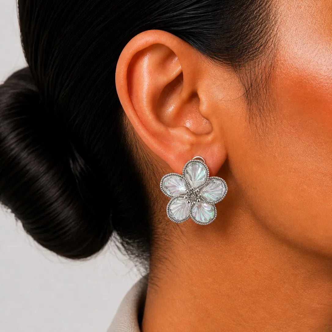 Close-up of an ear wearing a floral earring with a blurred background