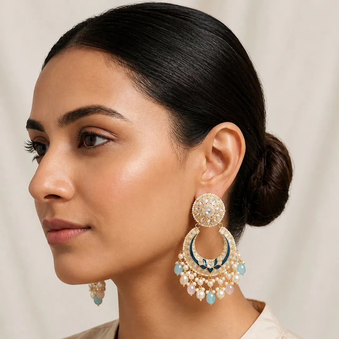 Woman wearing a pair of ornate earrings with a neutral background
