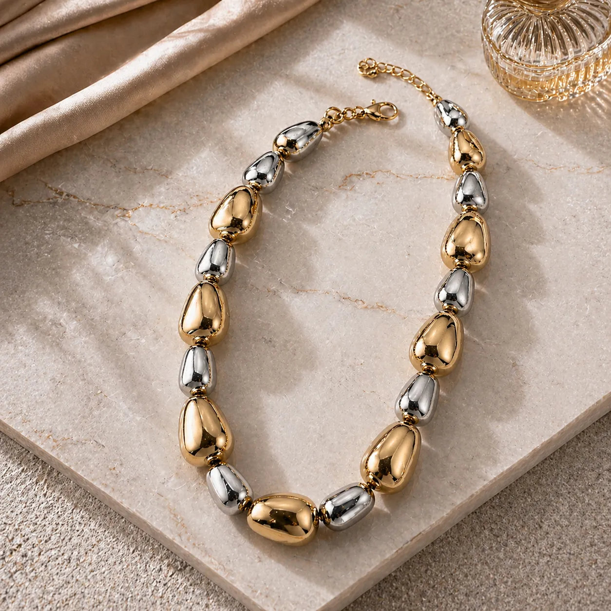 Gold and silver necklace on a marble surface