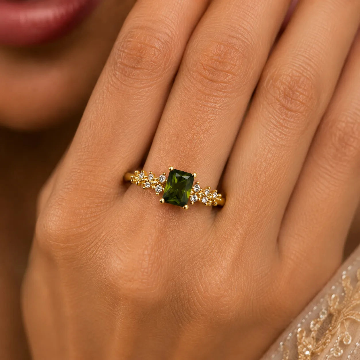 Gold ring with a green gemstone on a person's finger