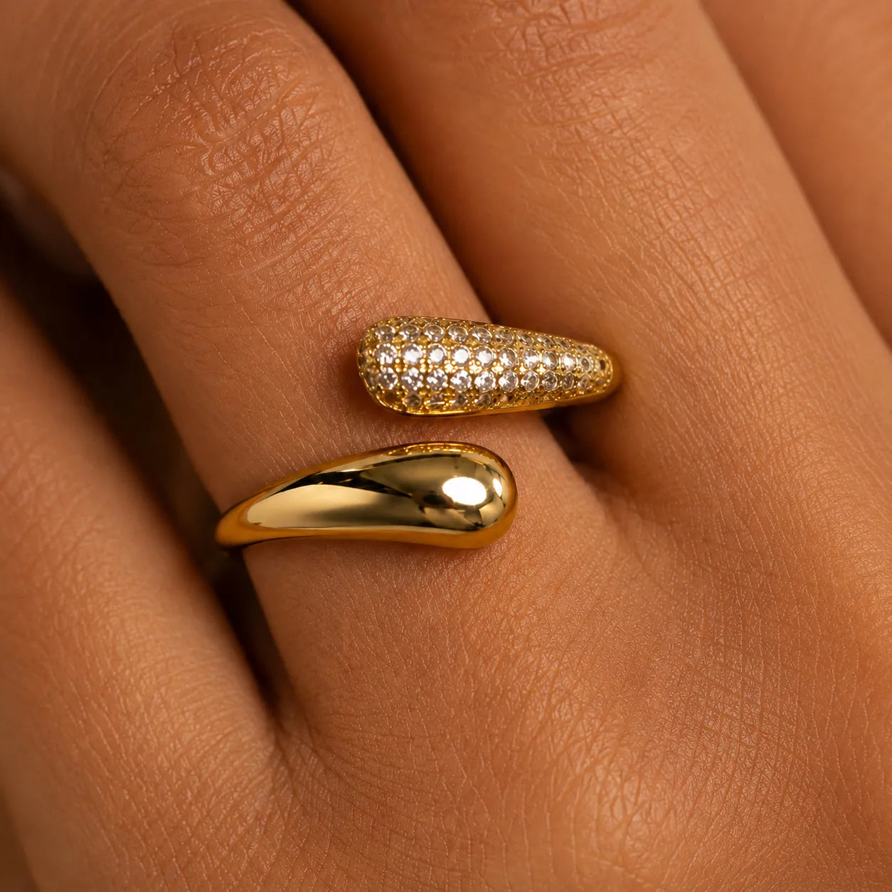 Two gold rings with diamond accents on a person's finger.