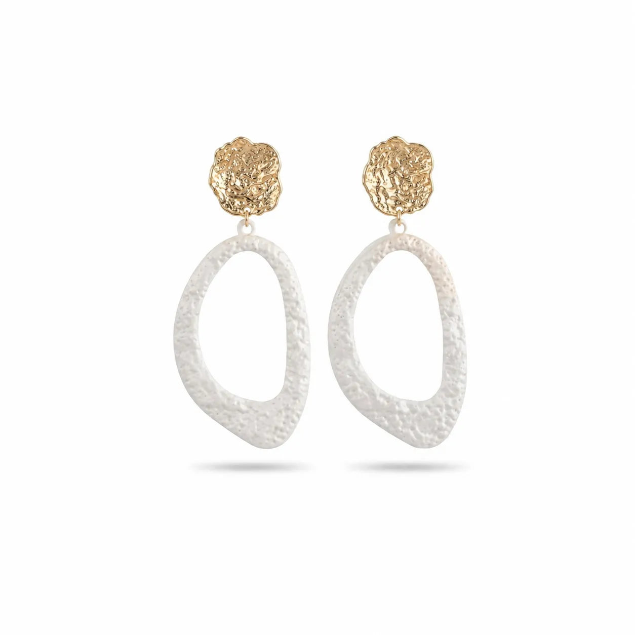 Gold and white earrings on a white background