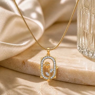 Gold necklace with a decorative pendant on a beige fabric background