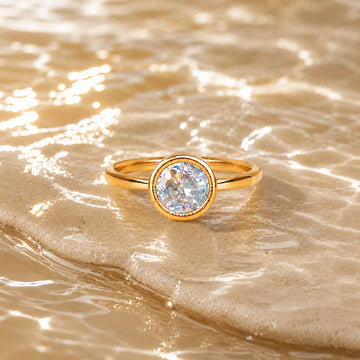 Gold ring with a diamond on a sandy surface