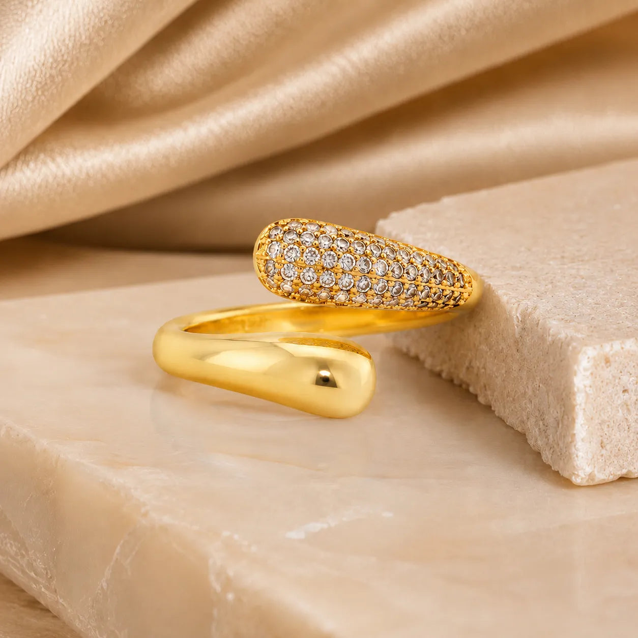 Gold ring with diamond accents on a beige fabric background