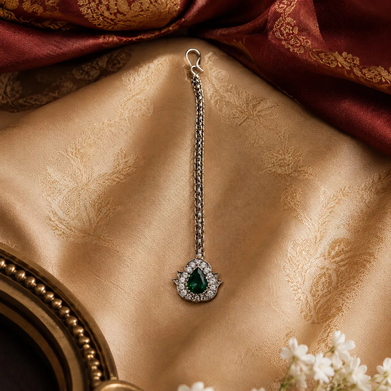 Earring with a green gemstone on a textured fabric background