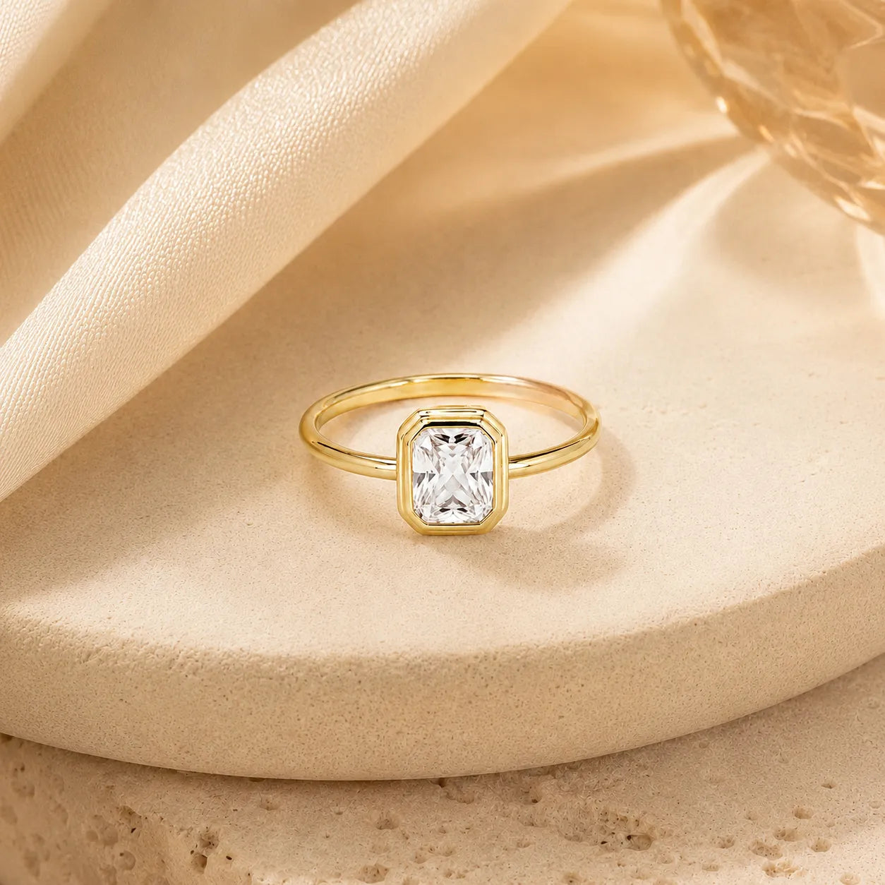 Gold ring with a diamond on a beige fabric background