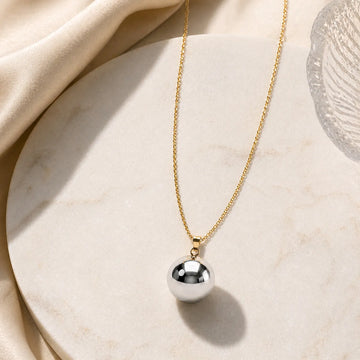 Necklace with a silver pendant on a beige fabric background
