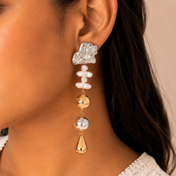 Close-up of a woman wearing a dangling earring with multiple beads.