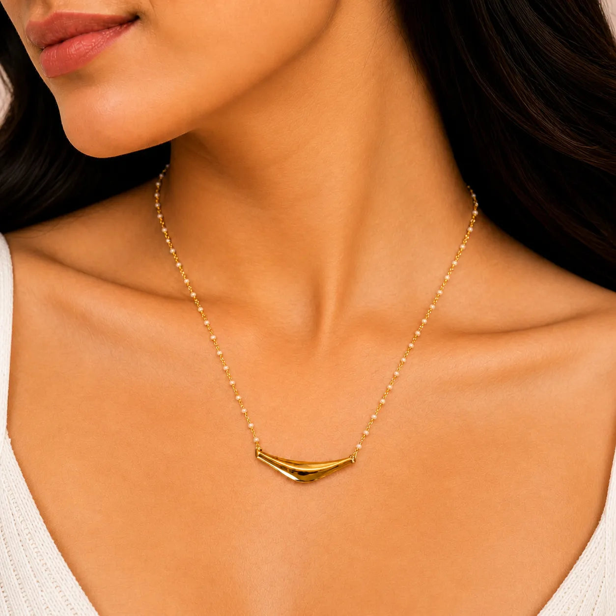 Gold necklace with a unique pendant on a model