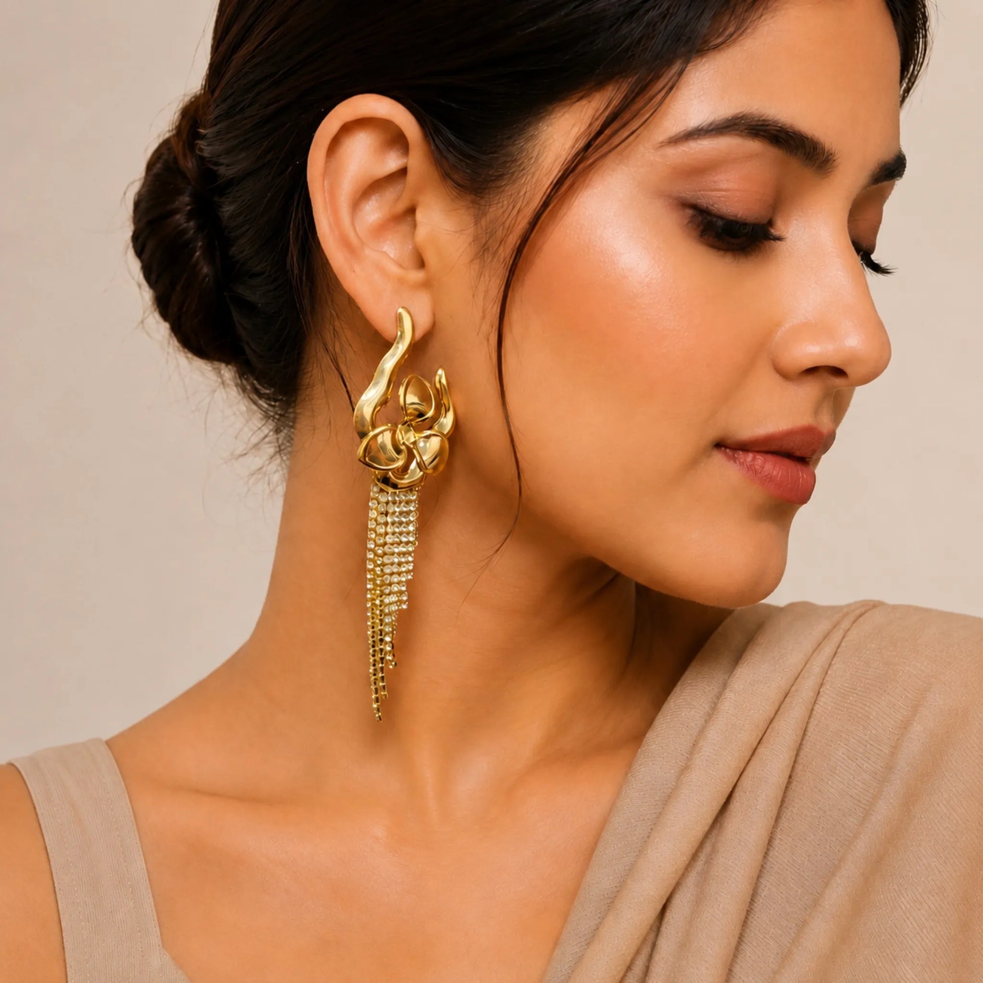Woman wearing a gold earring with a neutral background