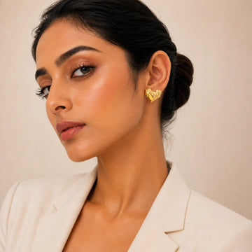 Woman wearing a gold earring against a neutral background
