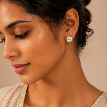 Close-up of a woman wearing a diamond earring against a neutral background