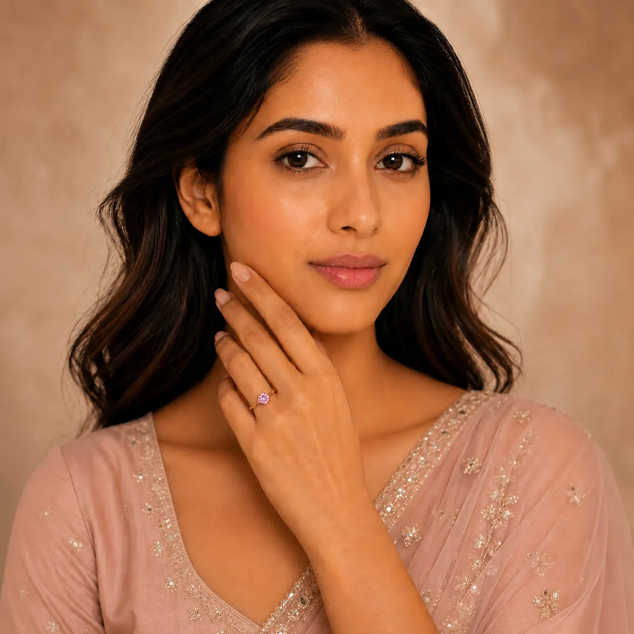 Woman wearing a pink saree with a neutral background