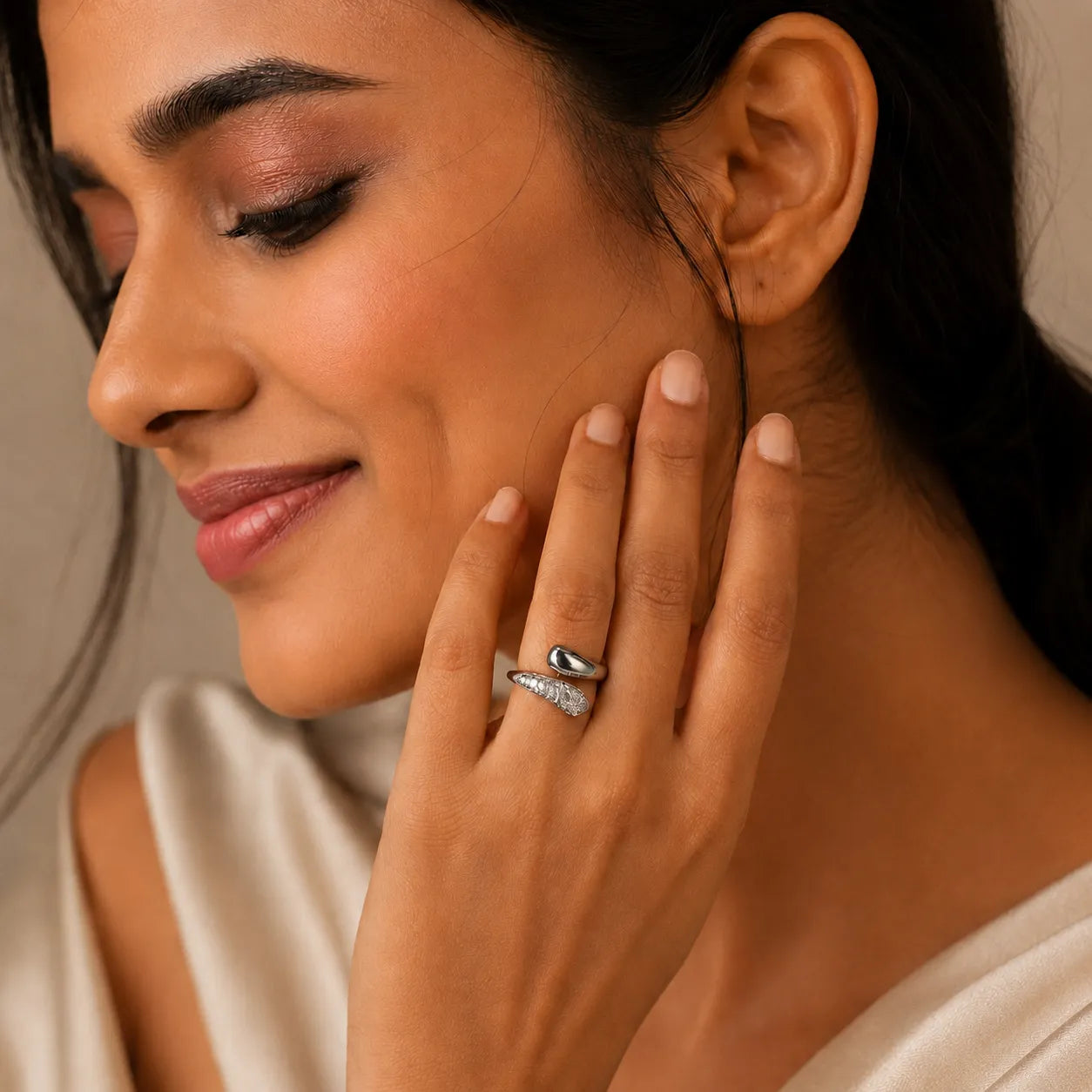 Woman wearing a silver ring with a black stone on a neutral background