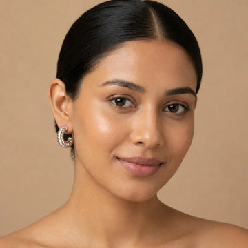Woman with a neutral expression against a beige background