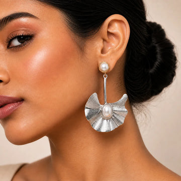 Close-up of a woman wearing silver earrings with pearl accents.