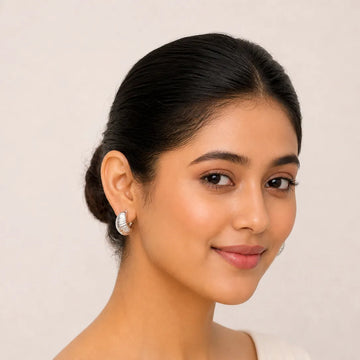 Woman wearing earrings with a plain background