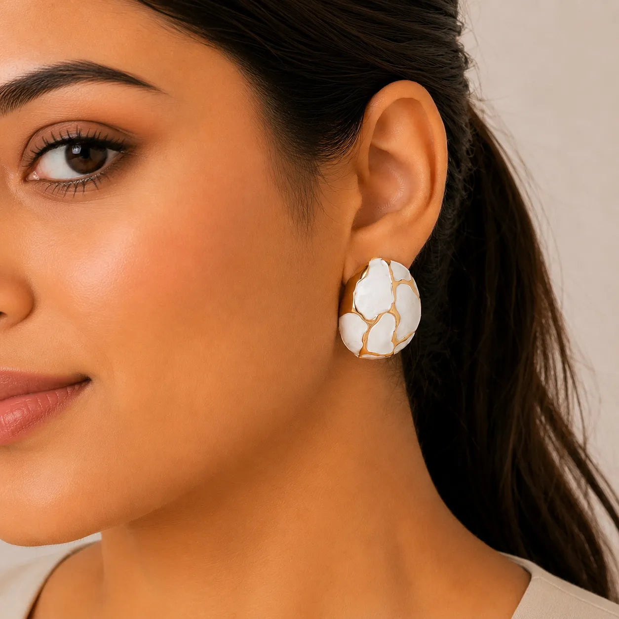Close-up of a woman wearing a floral earring with a neutral background
